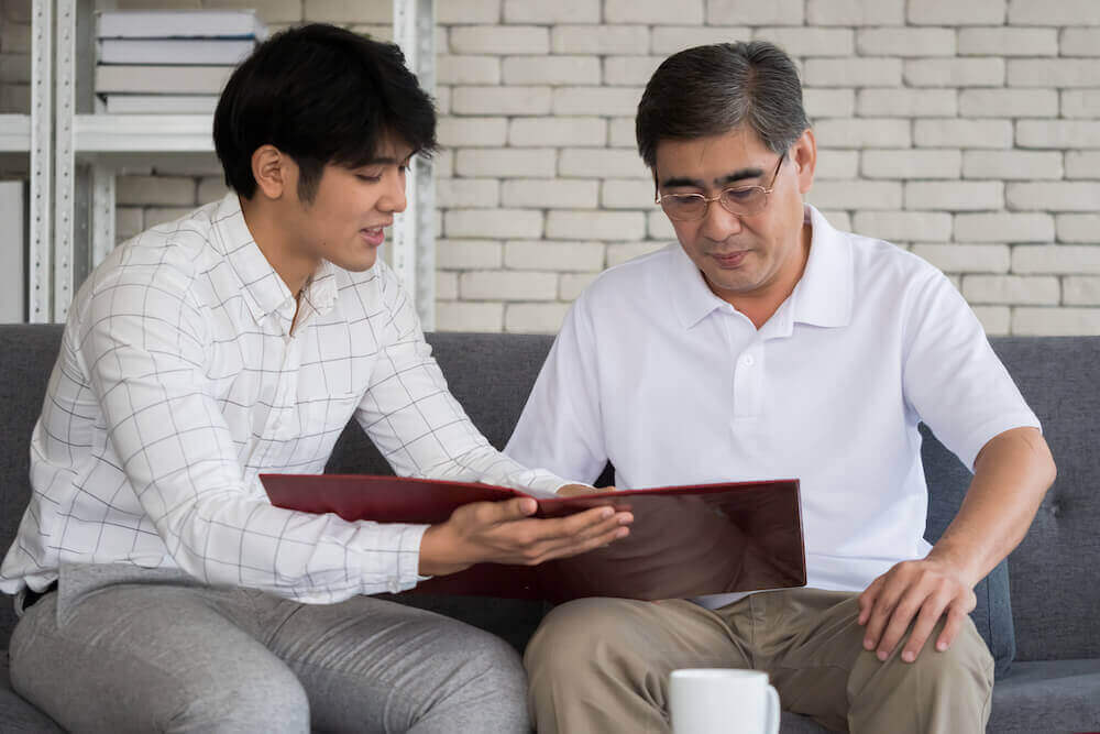 Young man agent recommending life insurance to senior man.